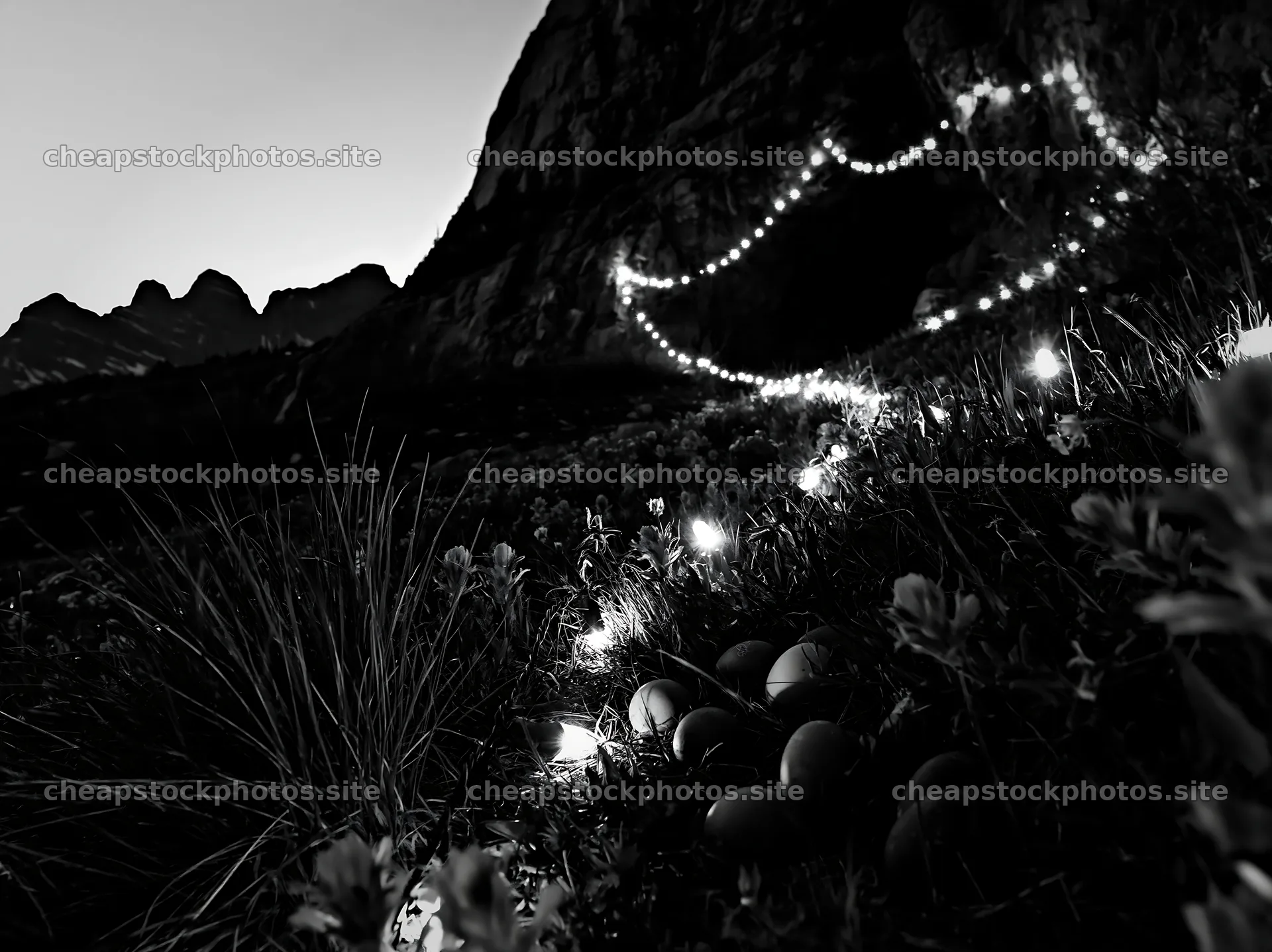 Christmas lights beside cave in meadow at dusk – stock photos 9174x6866