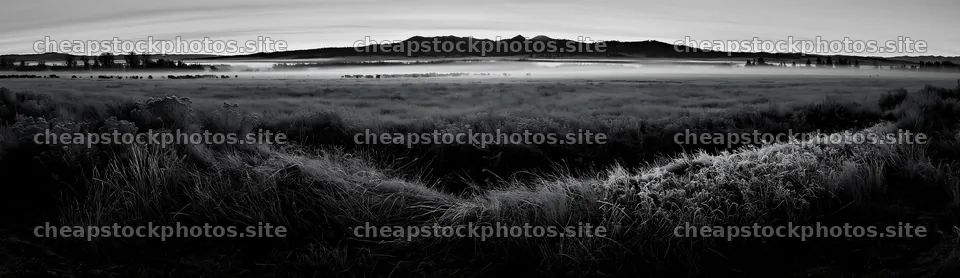 Frosty meadow at sunrise with distant mountains and mist – stock photos 14762x4268