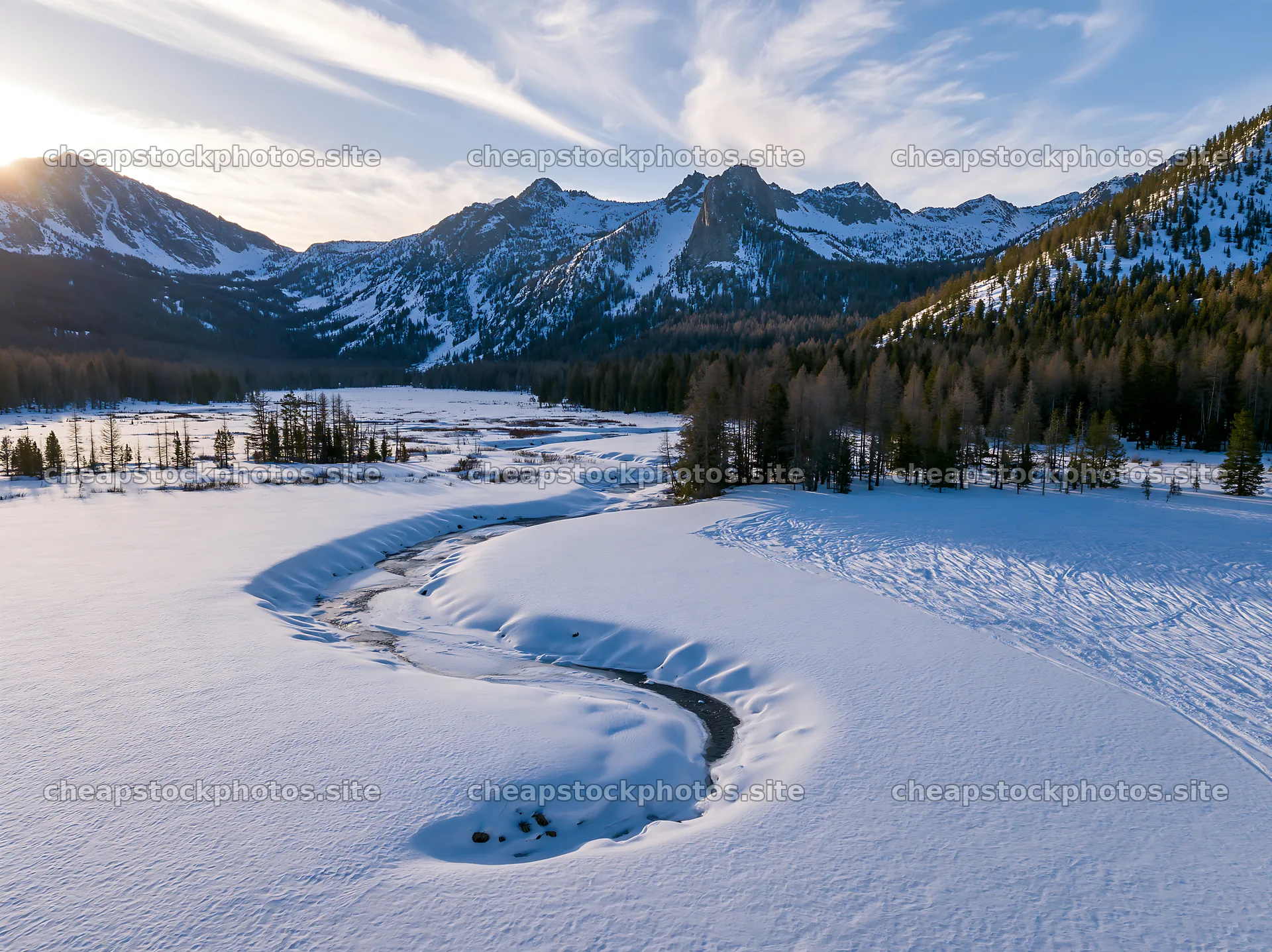 Aerial view of a snowy meadow valley with mountains in the distance – stock photos 9174x6866