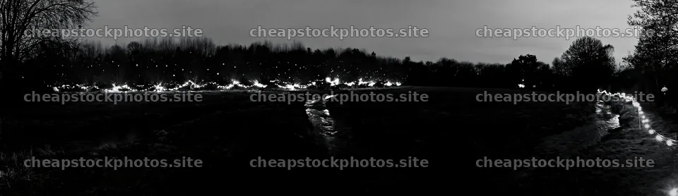Christmas lights at dusk beside stream in meadow – stock photos 14762x4268
