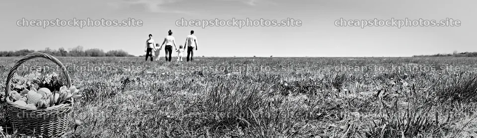 Easter basket in a meadow with people walking – stock photos 14762x4268
