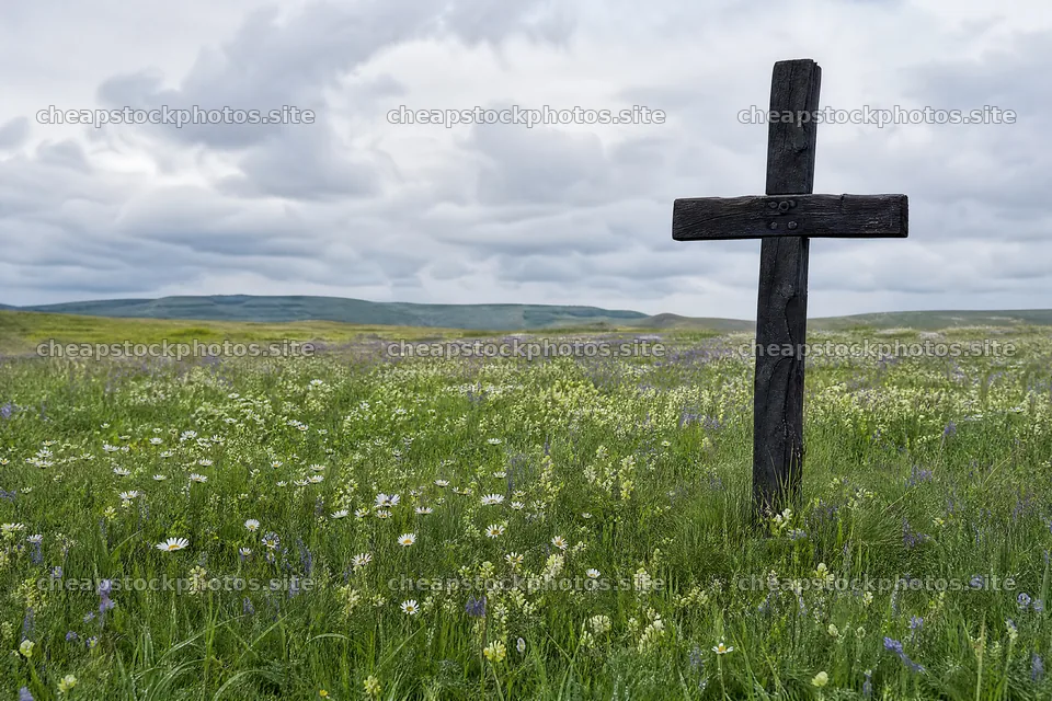 Rustic Christian cross in spring meadow with cloudy sky – stock photos 9722x6480