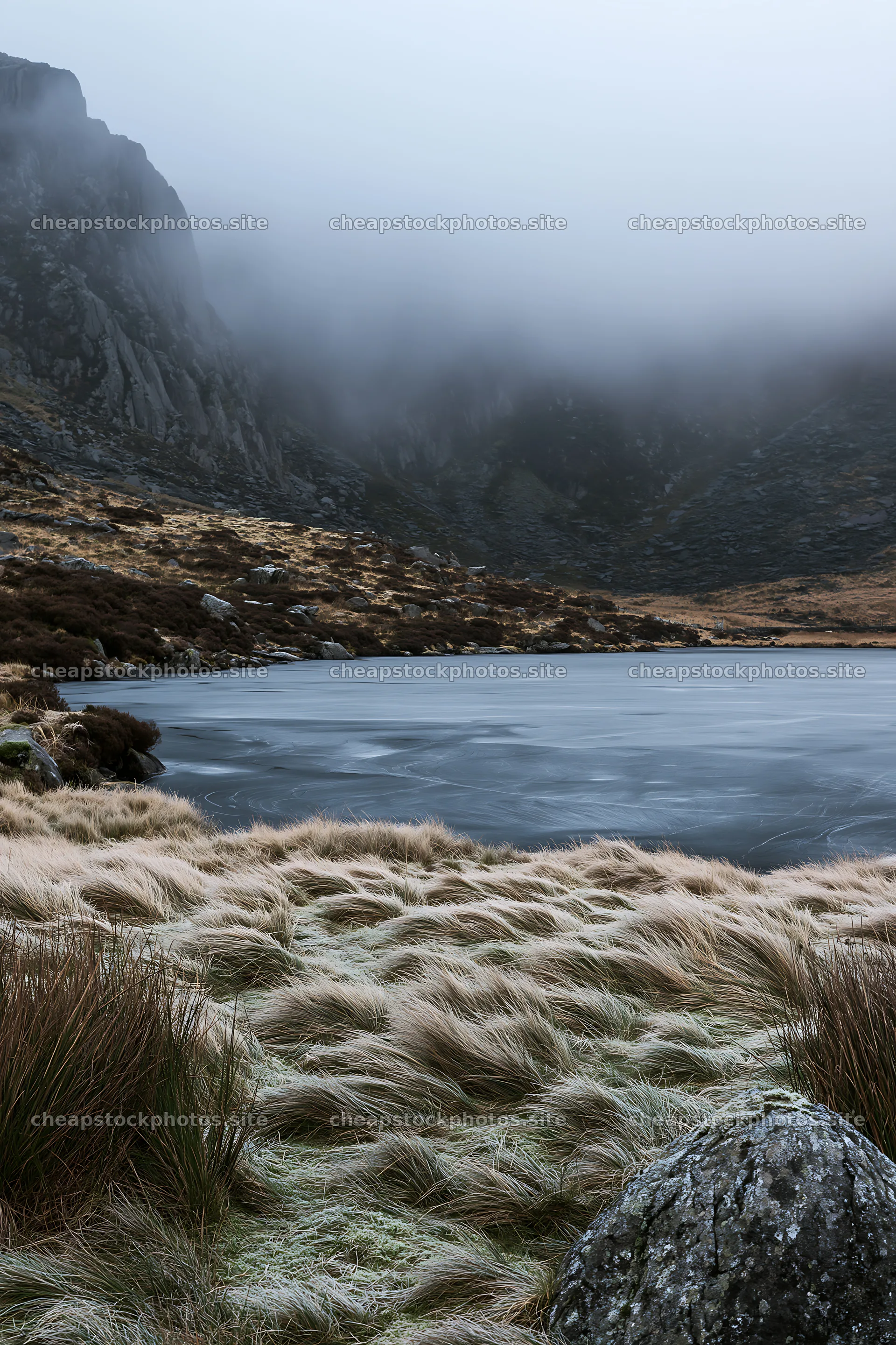 Frozen tarn meadow with mist and rocky hills in the background – stock photos 6480x9722