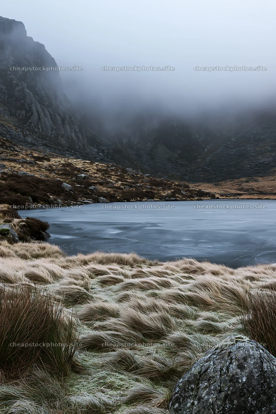 Frozen tarn meadow with mist and rocky hills in the background – stock photos 6480x9722