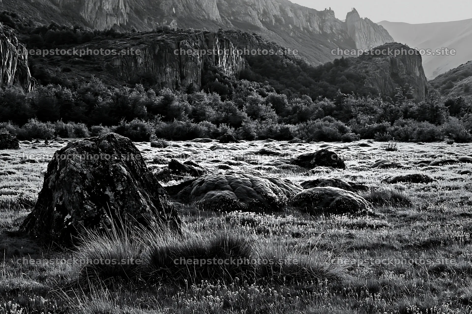 Mossy boulders in a meadow with rocky hills in the background – stock photos 9722x6480