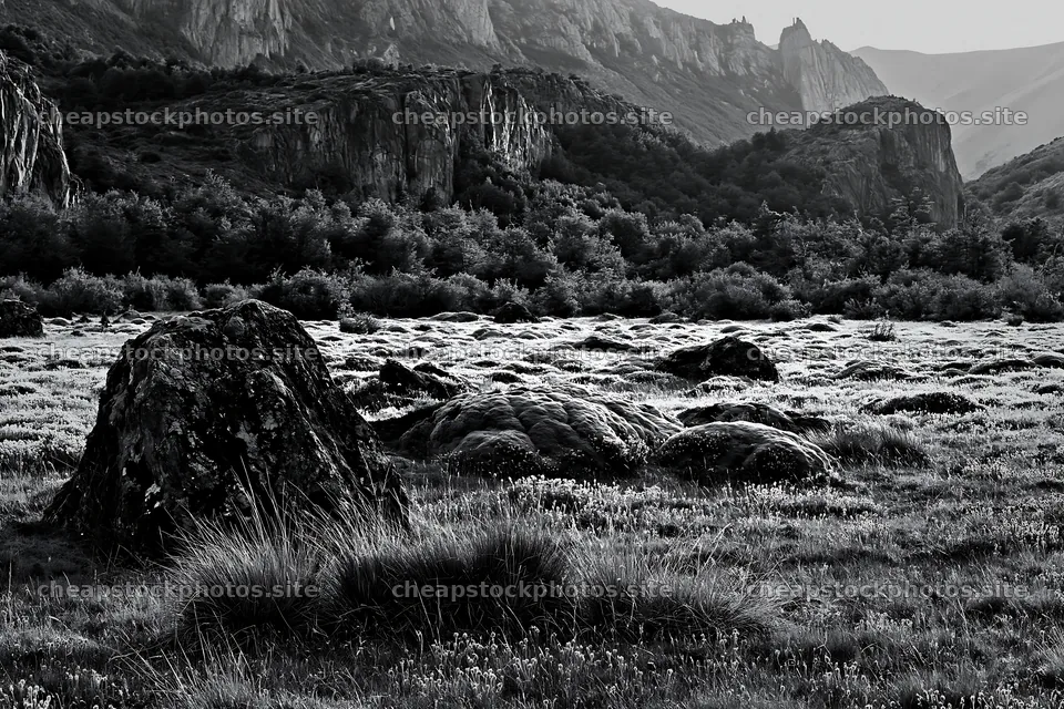 Mossy boulders in a meadow with rocky hills in the background – stock photos 9722x6480