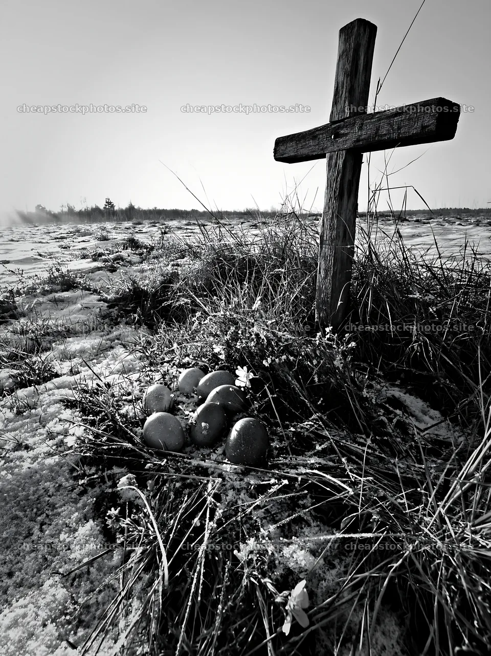 Weathered Christian cross in snowy meadow with orange eggs – stock photos 6866x9174