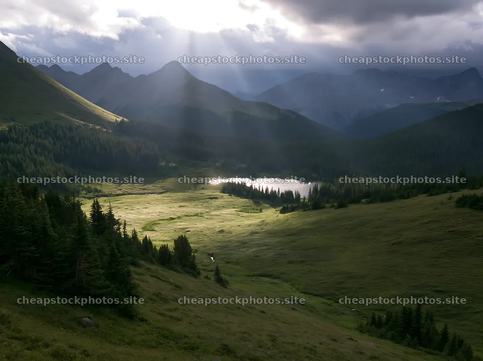 Sunshine rays over meadows and lake in Banff – stock photos 9174x6866