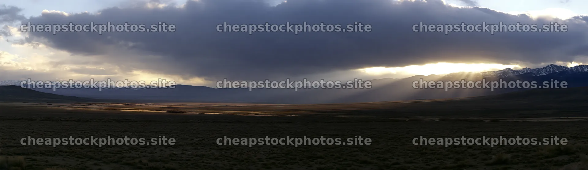 Meadow with mountains and sunrays reaching the ground – stock photos 14762x4268