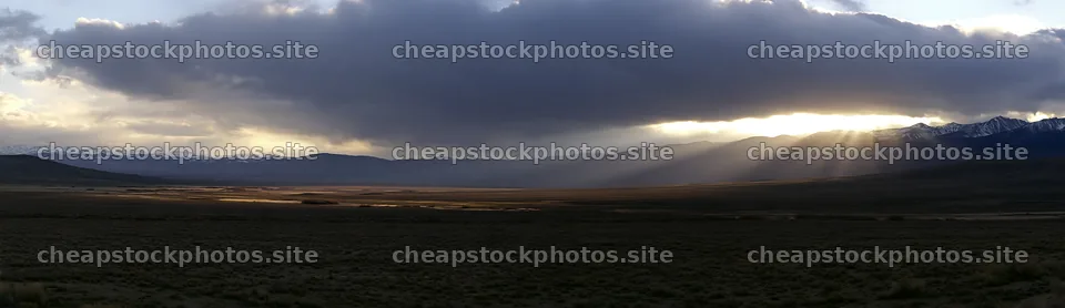 Meadow with mountains and sunrays reaching the ground – stock photos 14762x4268