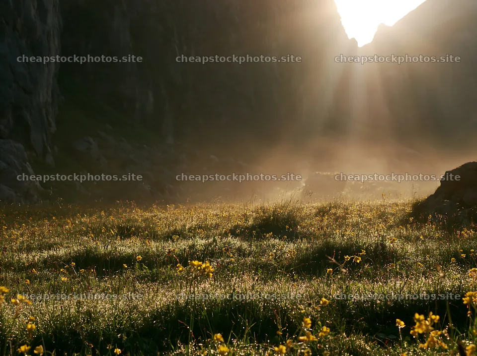 Meadow beneath crags with sunlight illuminating the landscape – stock photos 9174x6866